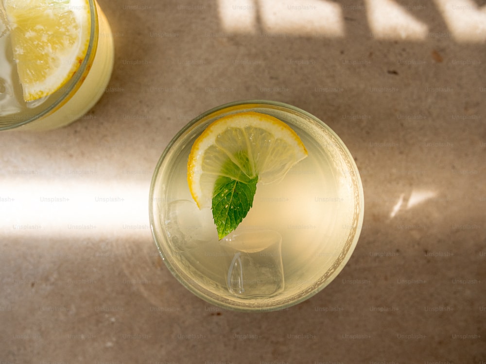 un bicchiere di acqua e limone con una fetta di limone