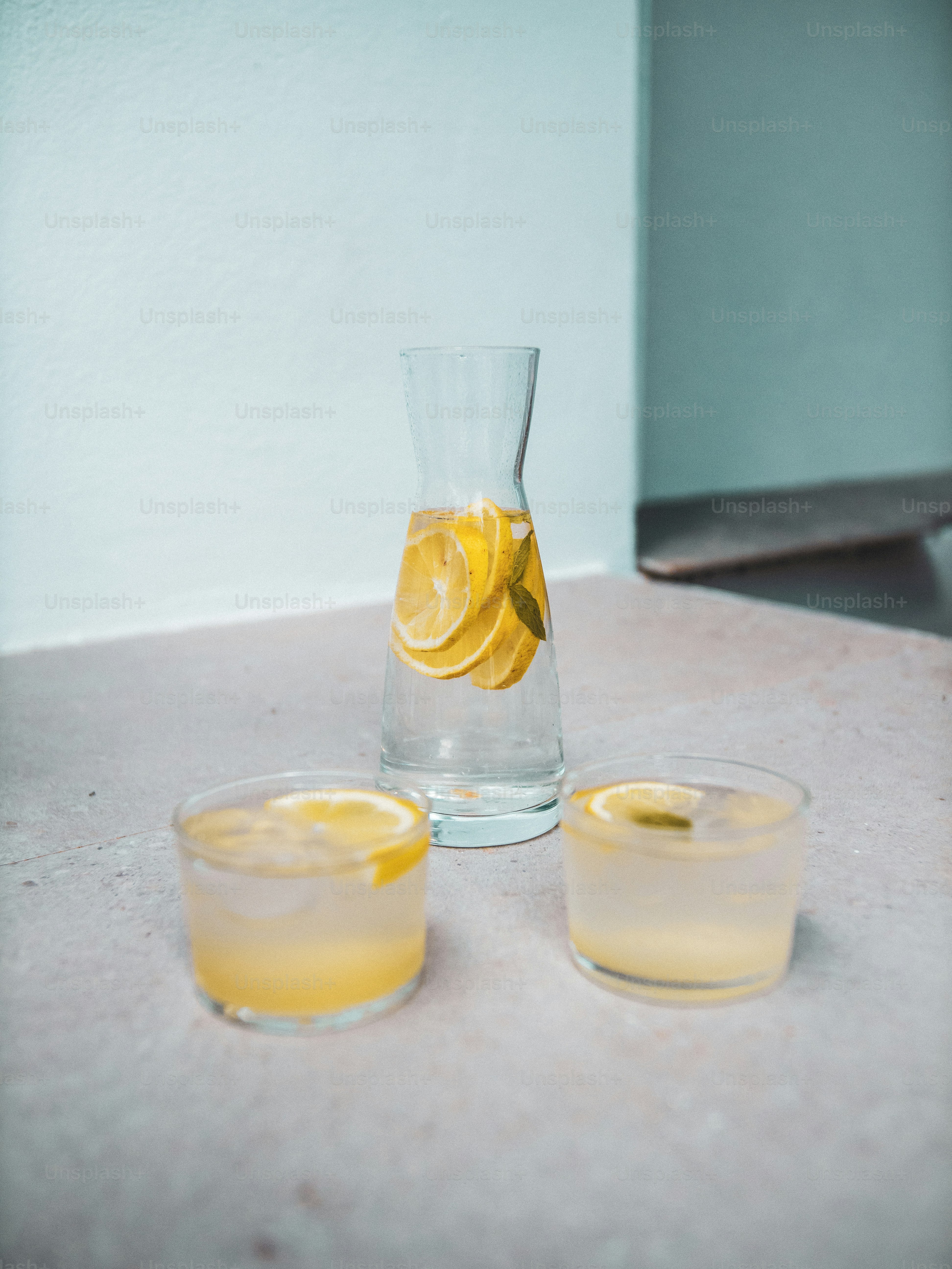 a pitcher and two glasses filled with lemonade