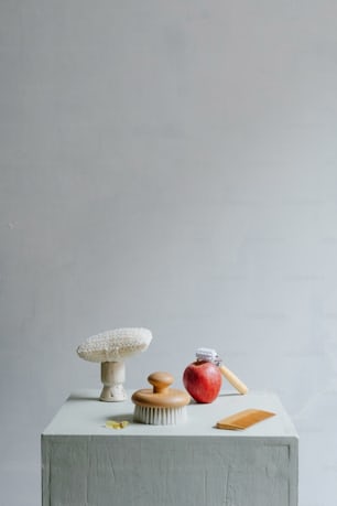 a table topped with an apple and a cupcake
