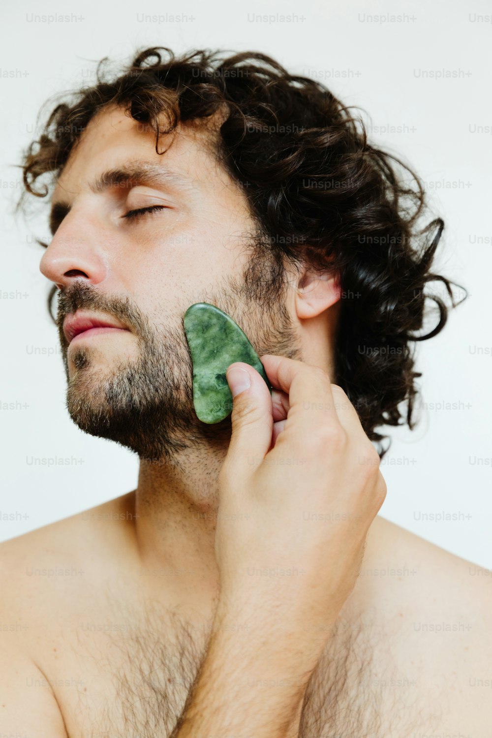 a man holding a piece of broccoli to his face