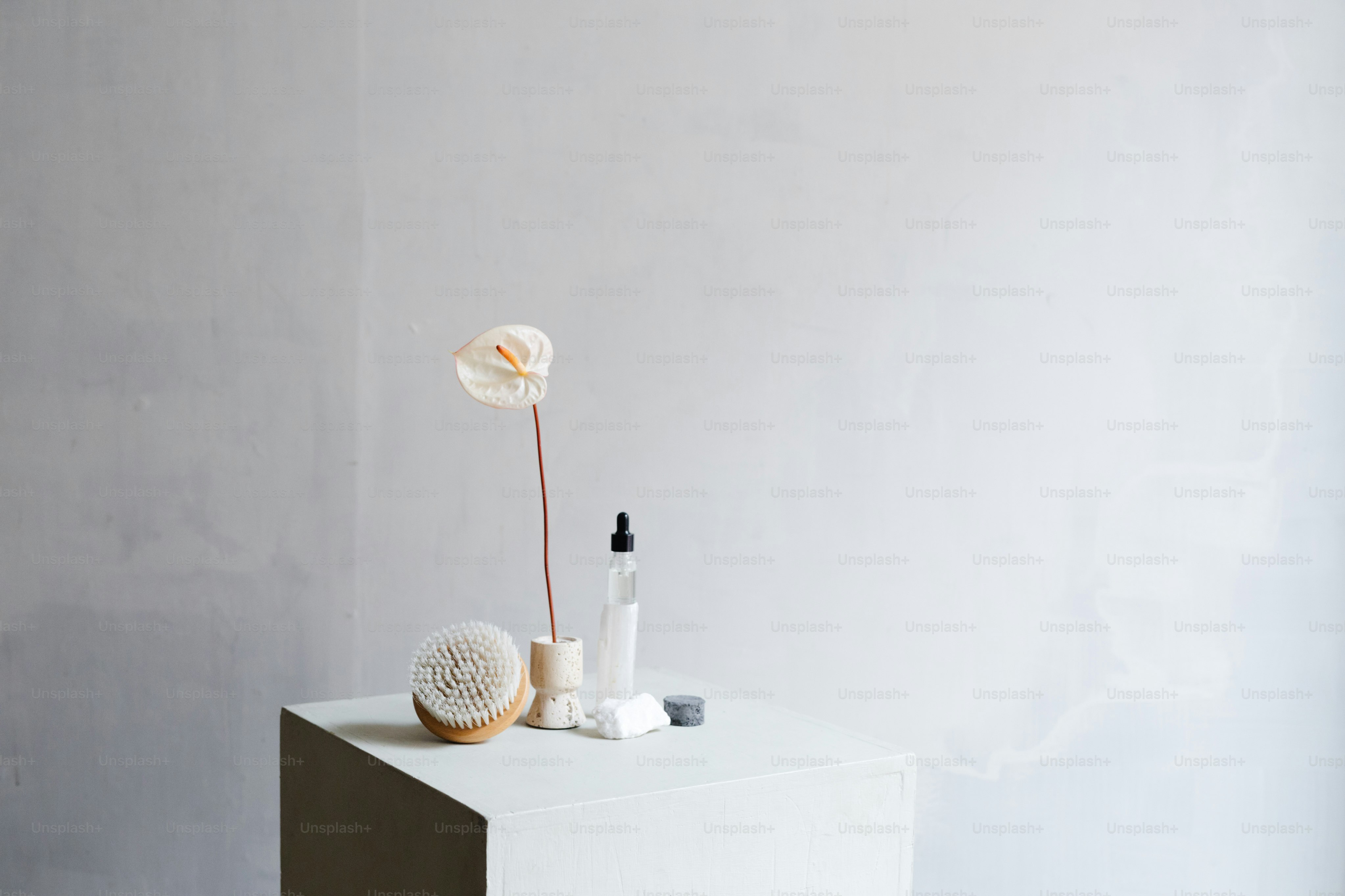 a vase with a flower and a bottle of lotion