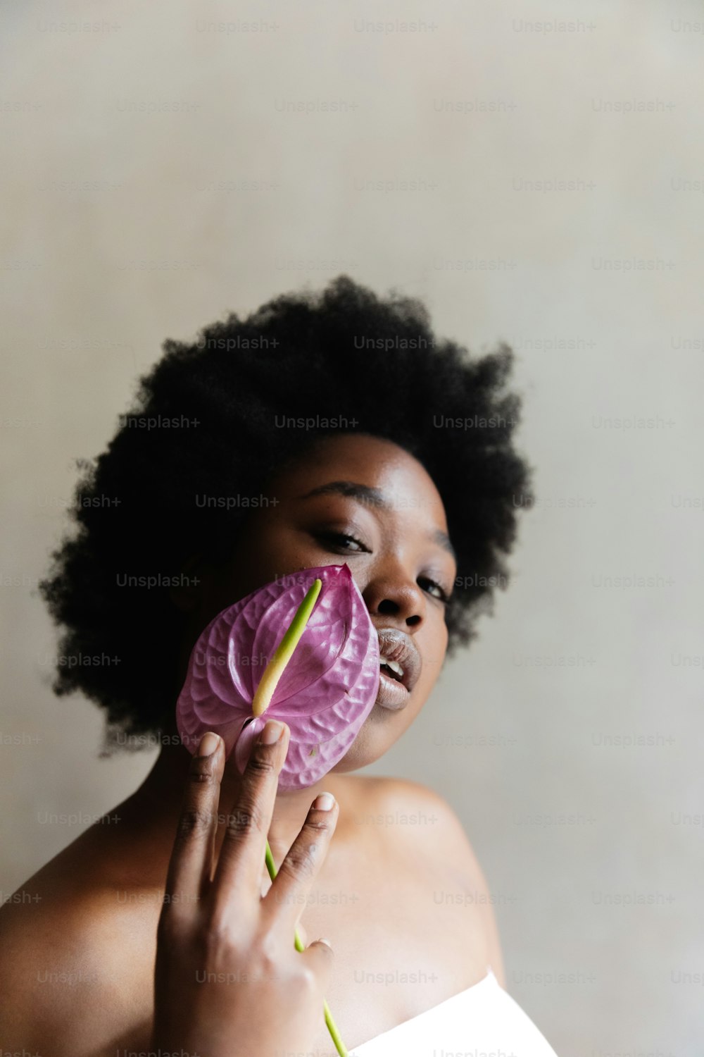 Una mujer sosteniendo una flor en su cara
