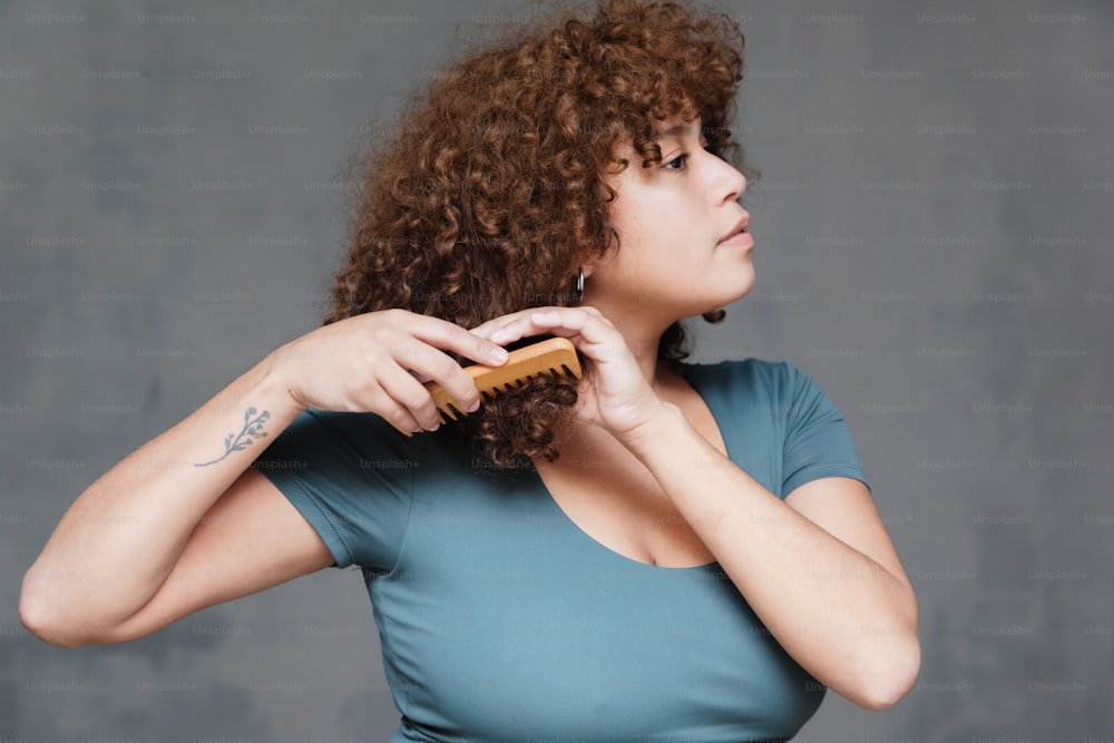 a woman brushing her hair with a brush