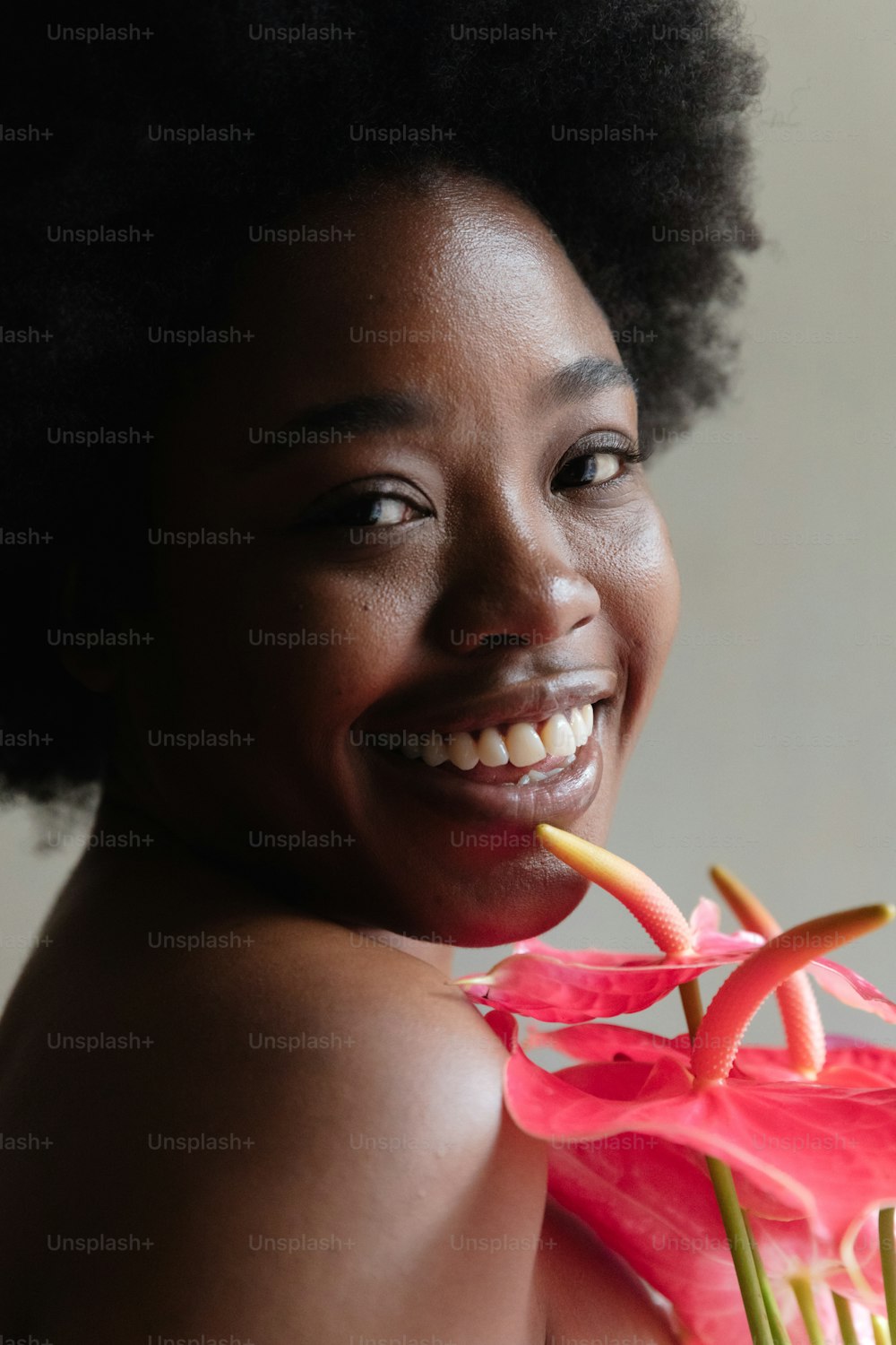 a woman smiling and holding a flower in her hand