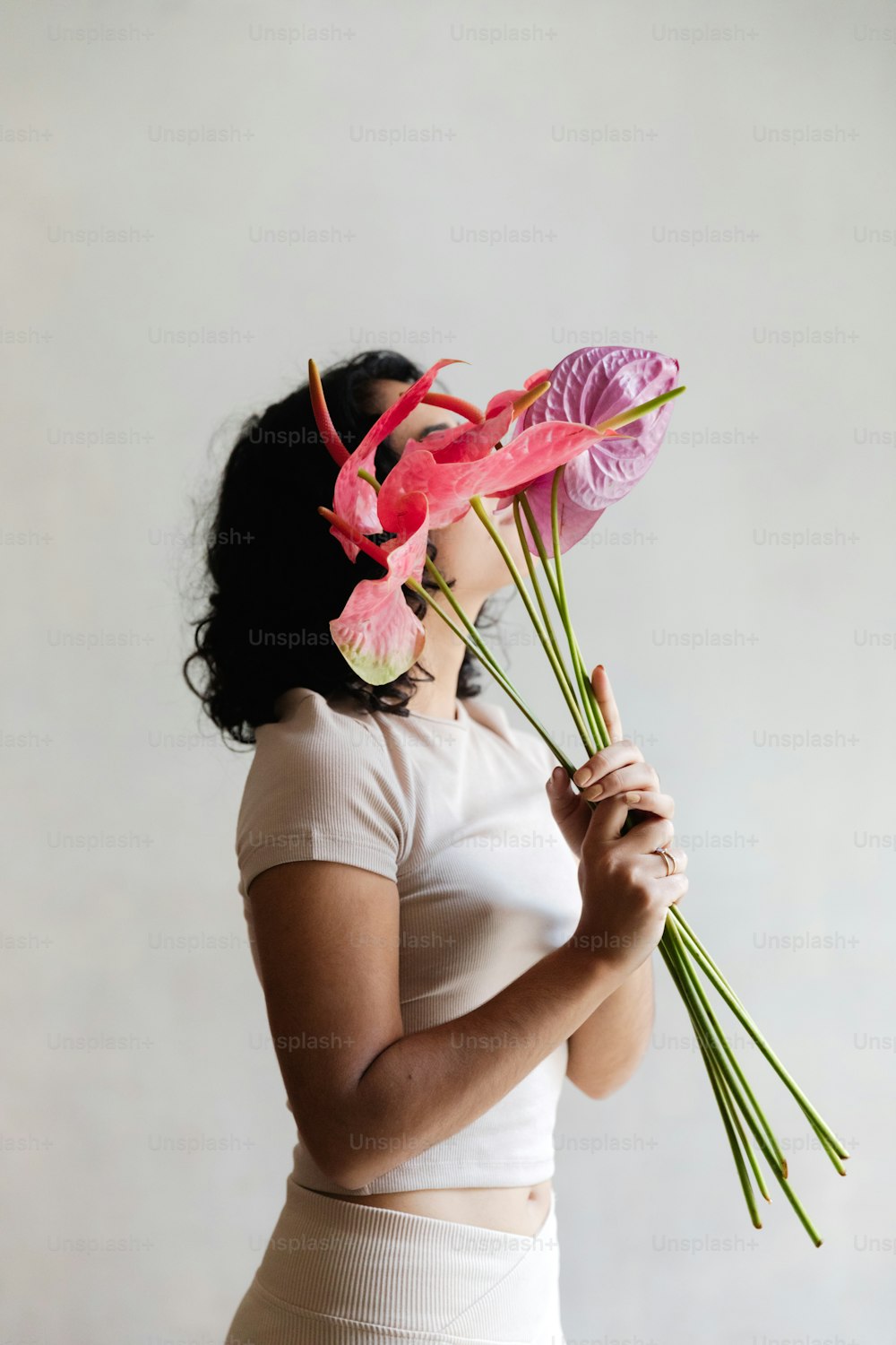 a woman holding a bunch of pink flowers