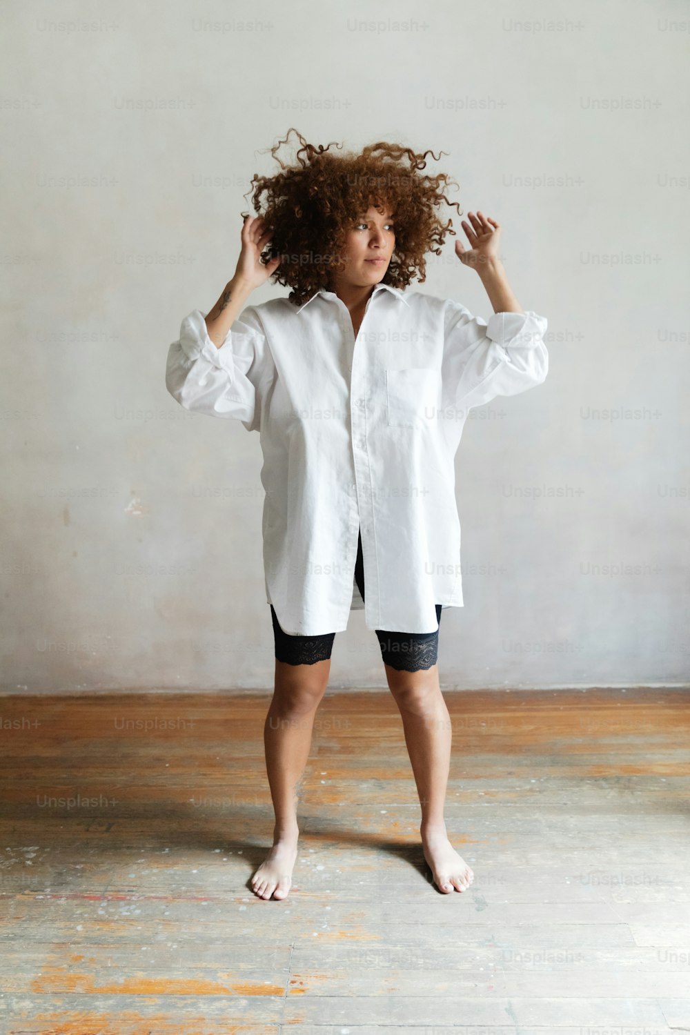 a woman with curly hair standing in a room