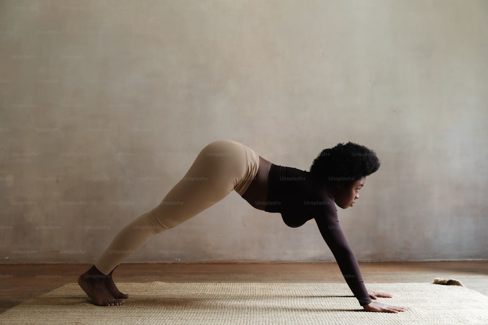 a woman is doing a yoga pose on a mat