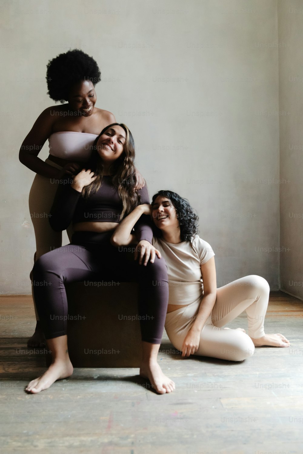 a group of three women sitting on top of a chair