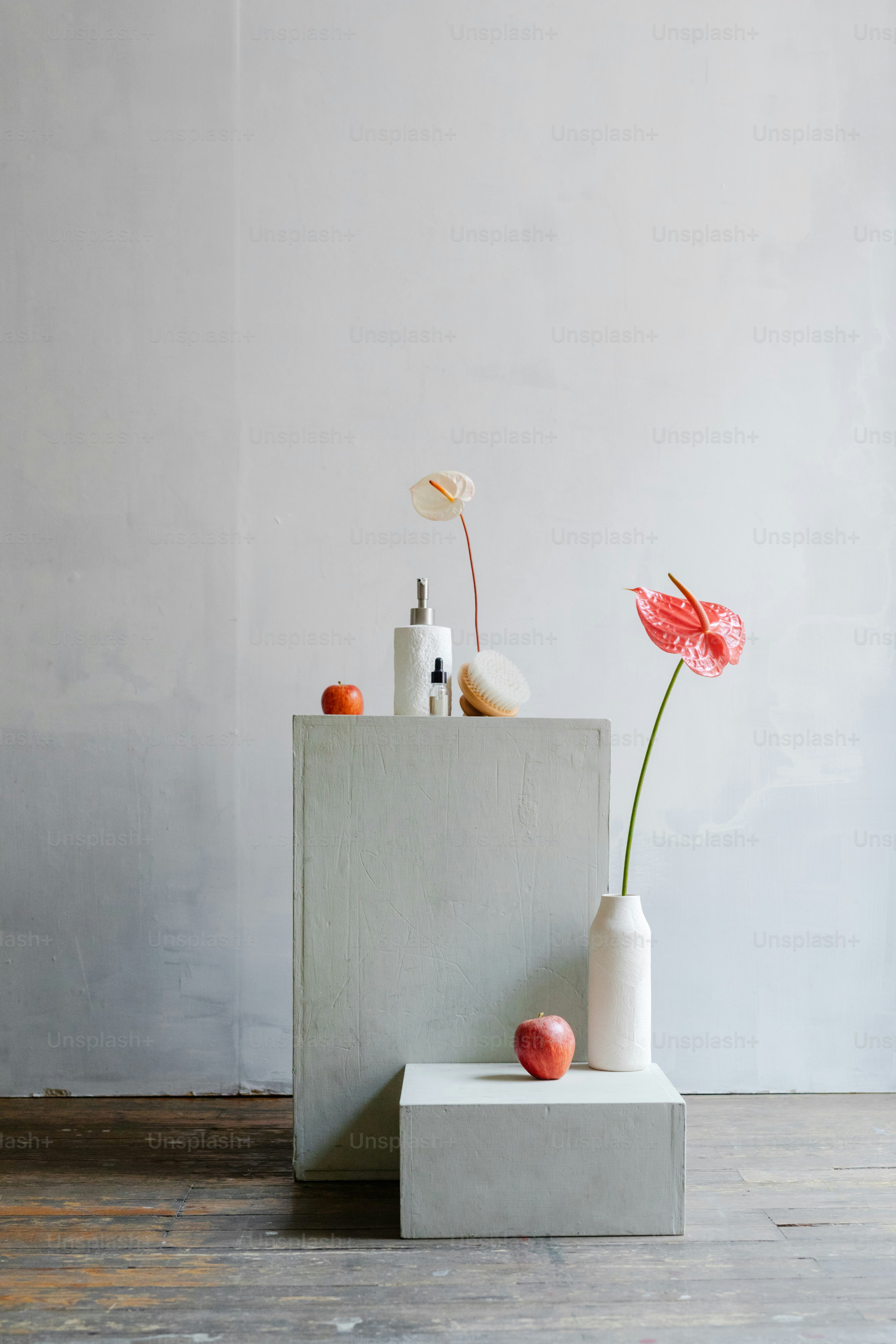 a vase with a flower and a bottle on a table
