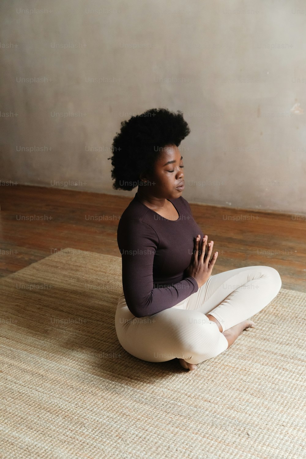 uma mulher sentada no chão em uma pose de ioga