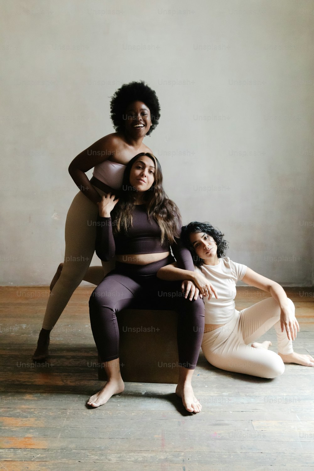 a group of three women sitting on top of a chair
