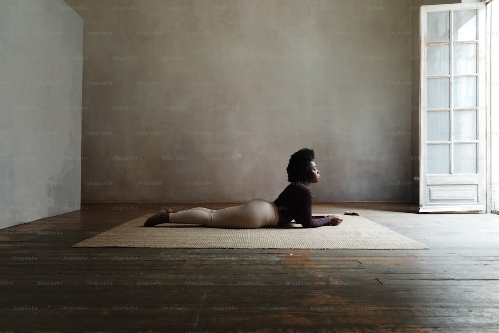 Une femme assise sur un tapis dans une pièce