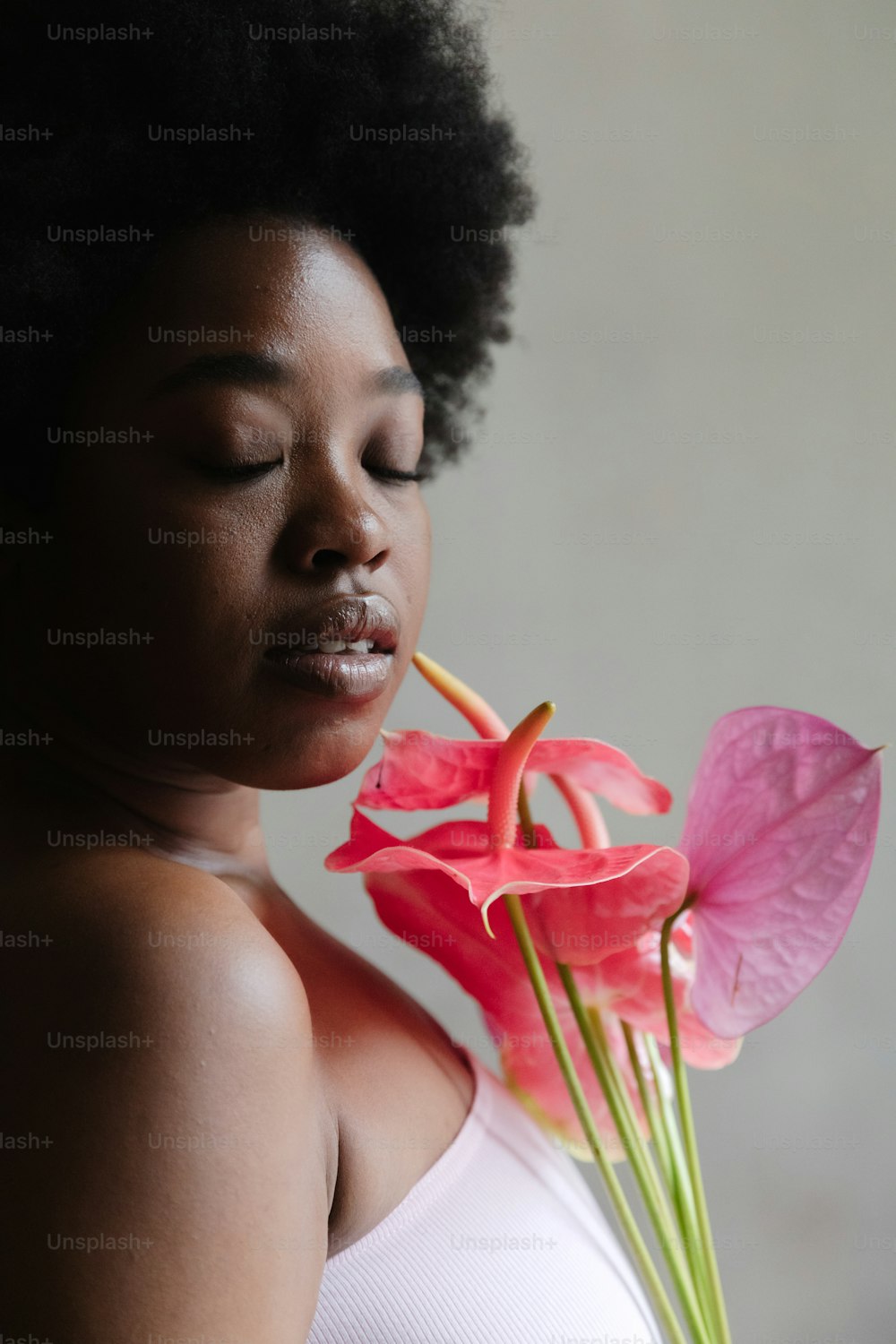 Eine Frau, die eine rosa Blume im Mund hält