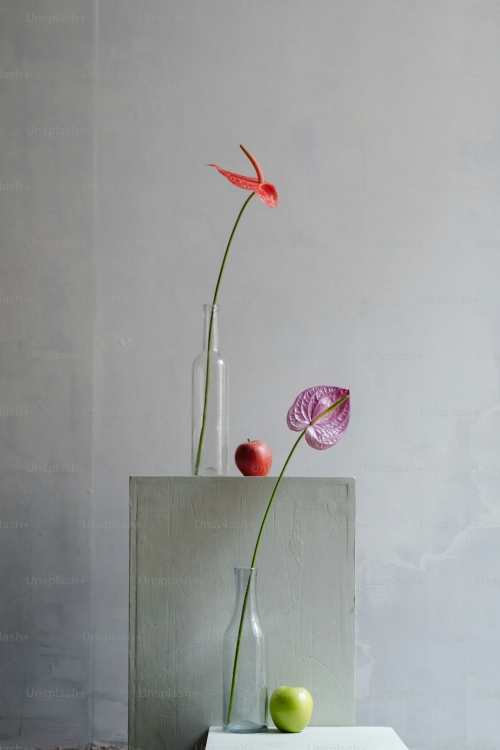 eine Vase mit zwei Blumen darin, die auf einem Tisch sitzt