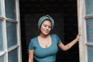 a woman with a towel on her head standing in a doorway