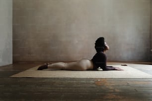 a woman sitting on a rug in a room