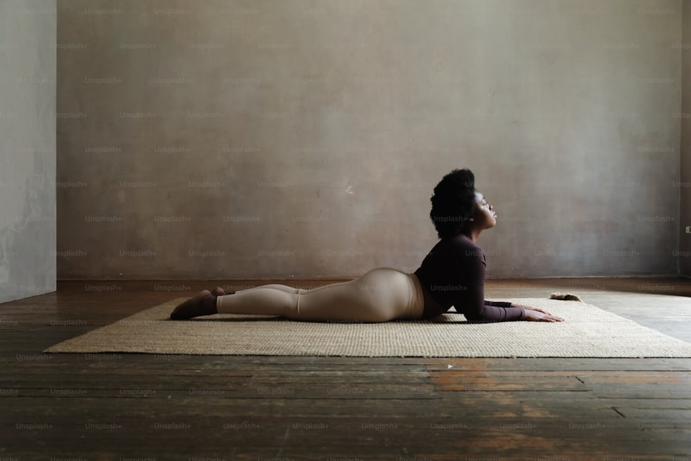 uma mulher sentada em um tapete em um quarto