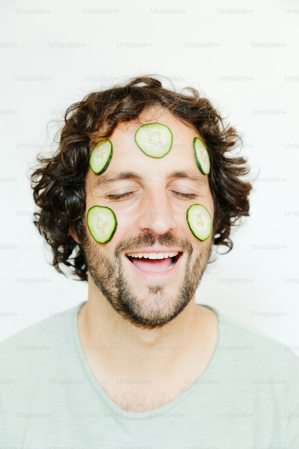 Un homme avec des tranches de concombre sur le visage