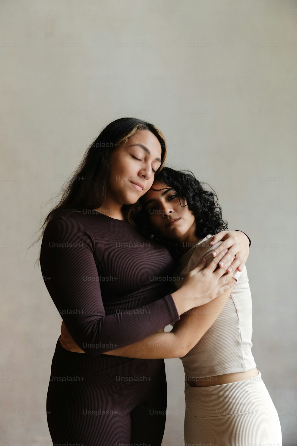 two women hugging each other in a studio