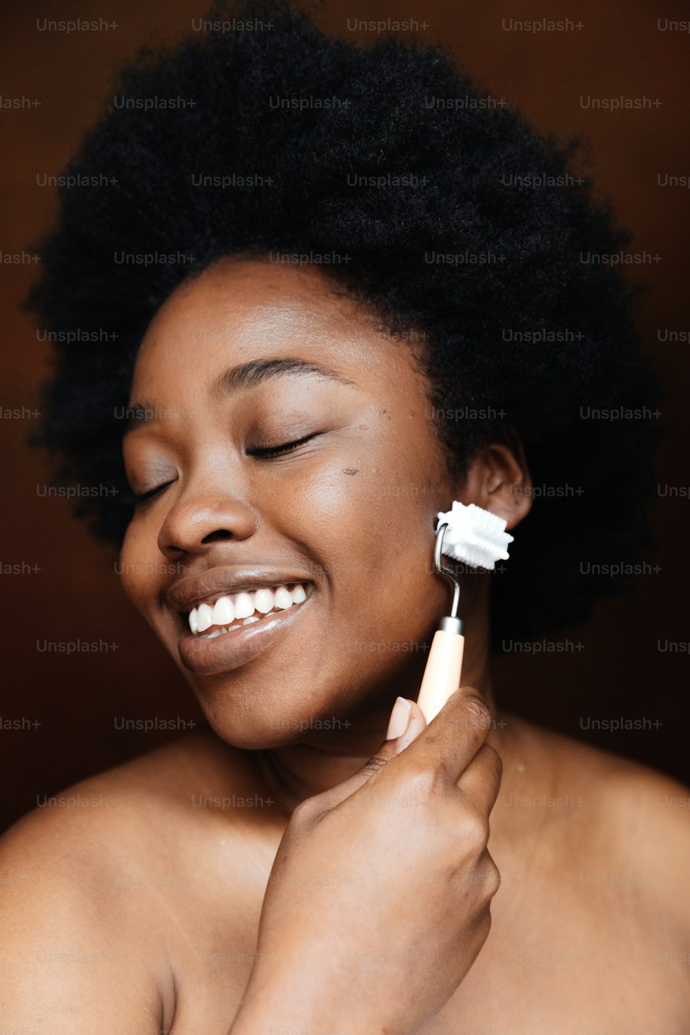uma mulher escovando os dentes com uma escova de dentes elétrica