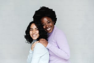 two women hugging each other and smiling