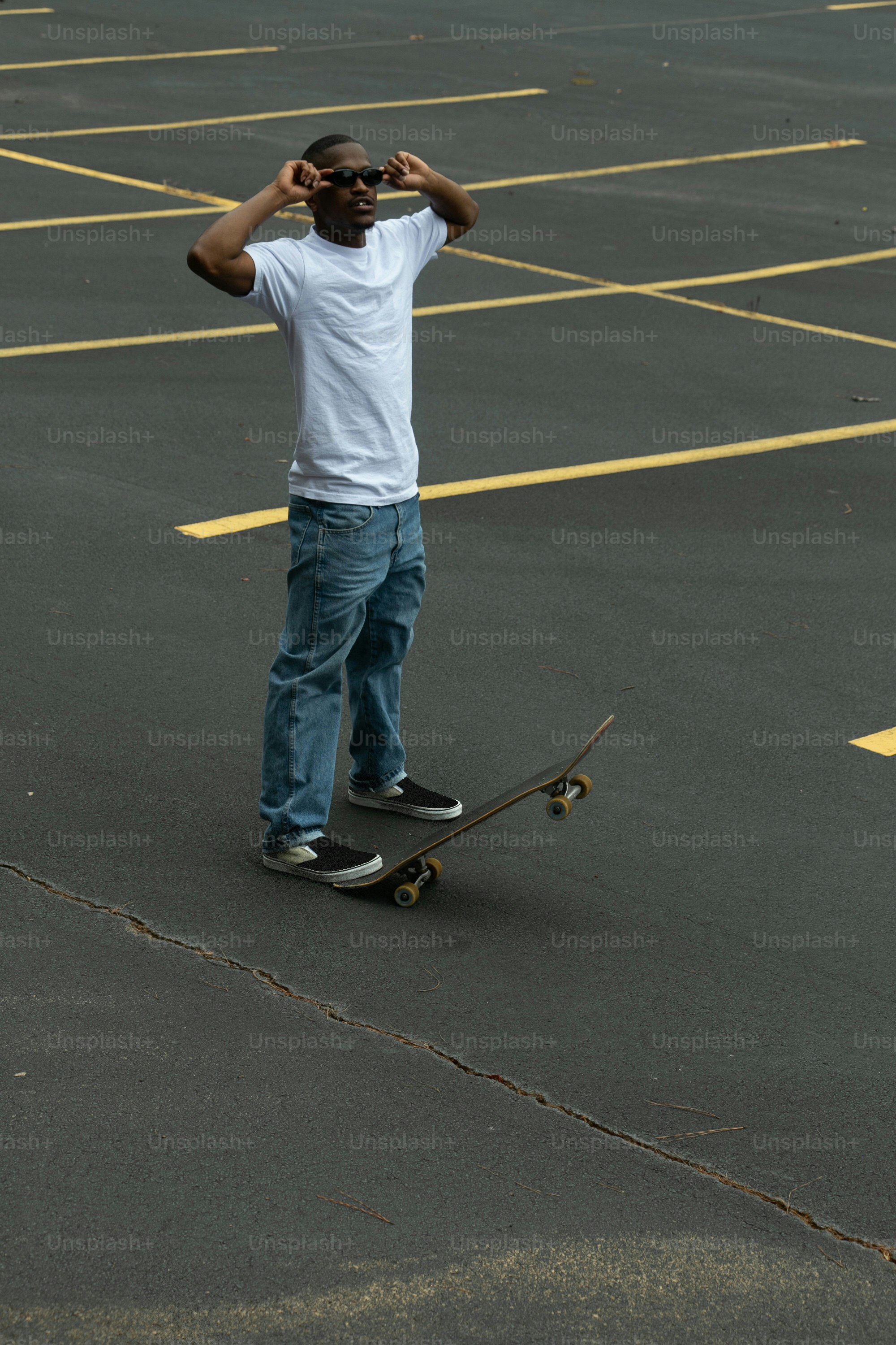 a man standing on a skateboard in a parking lot