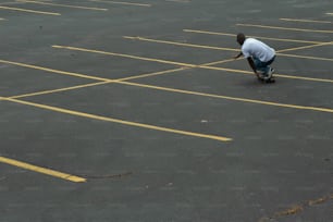 a man riding a skateboard across a parking lot