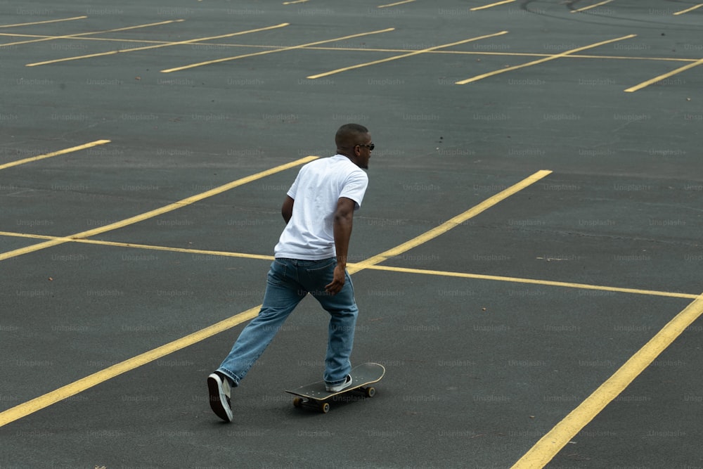 Ein Mann, der mit einem Skateboard über einen Parkplatz fährt