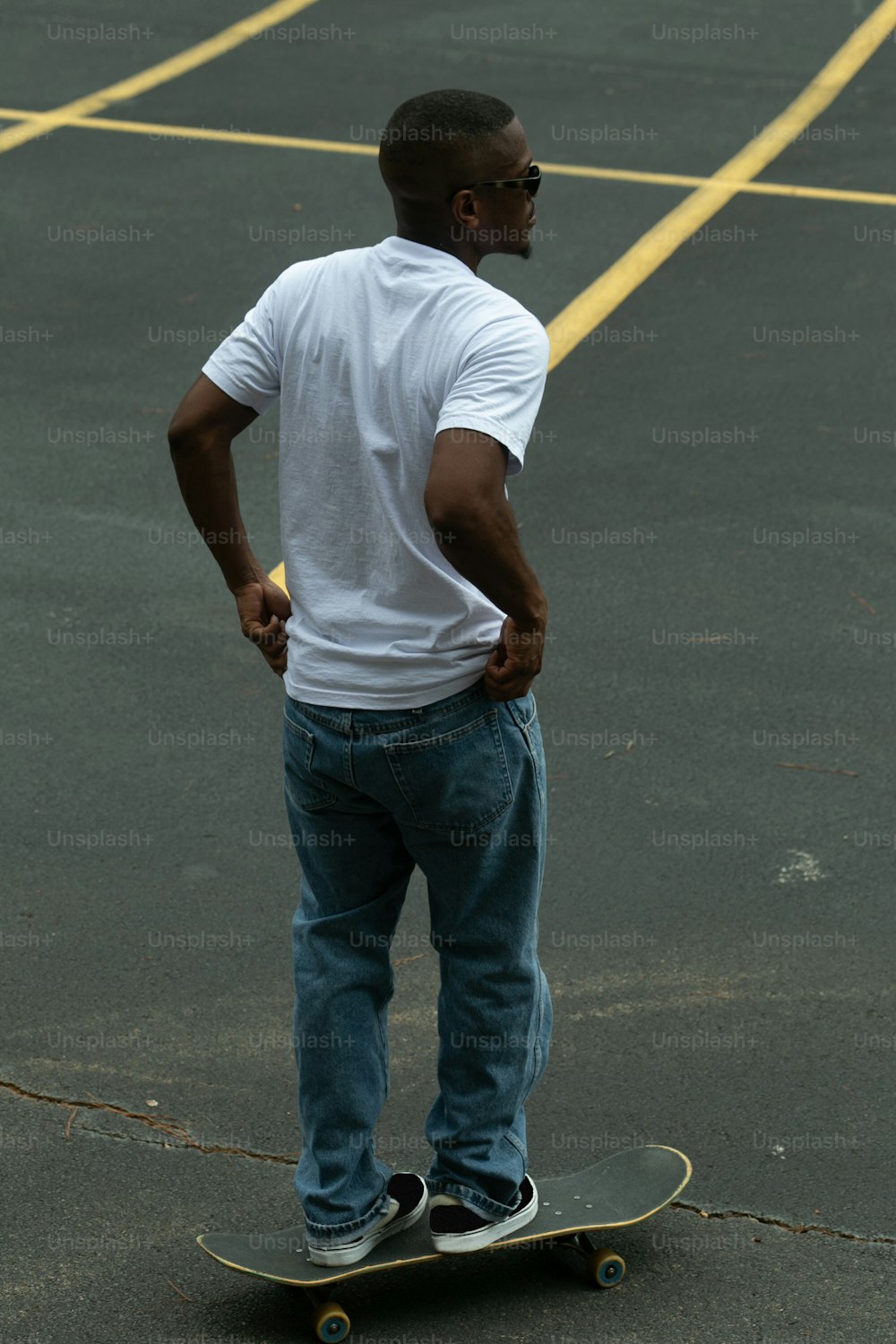 a man standing on a skateboard in a parking lot