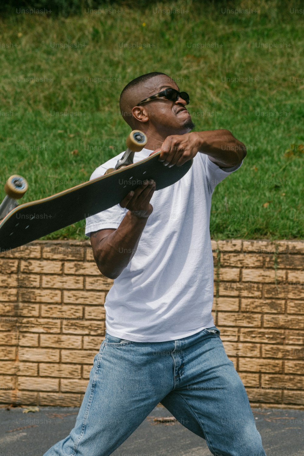 um homem segurando um skate na mão direita