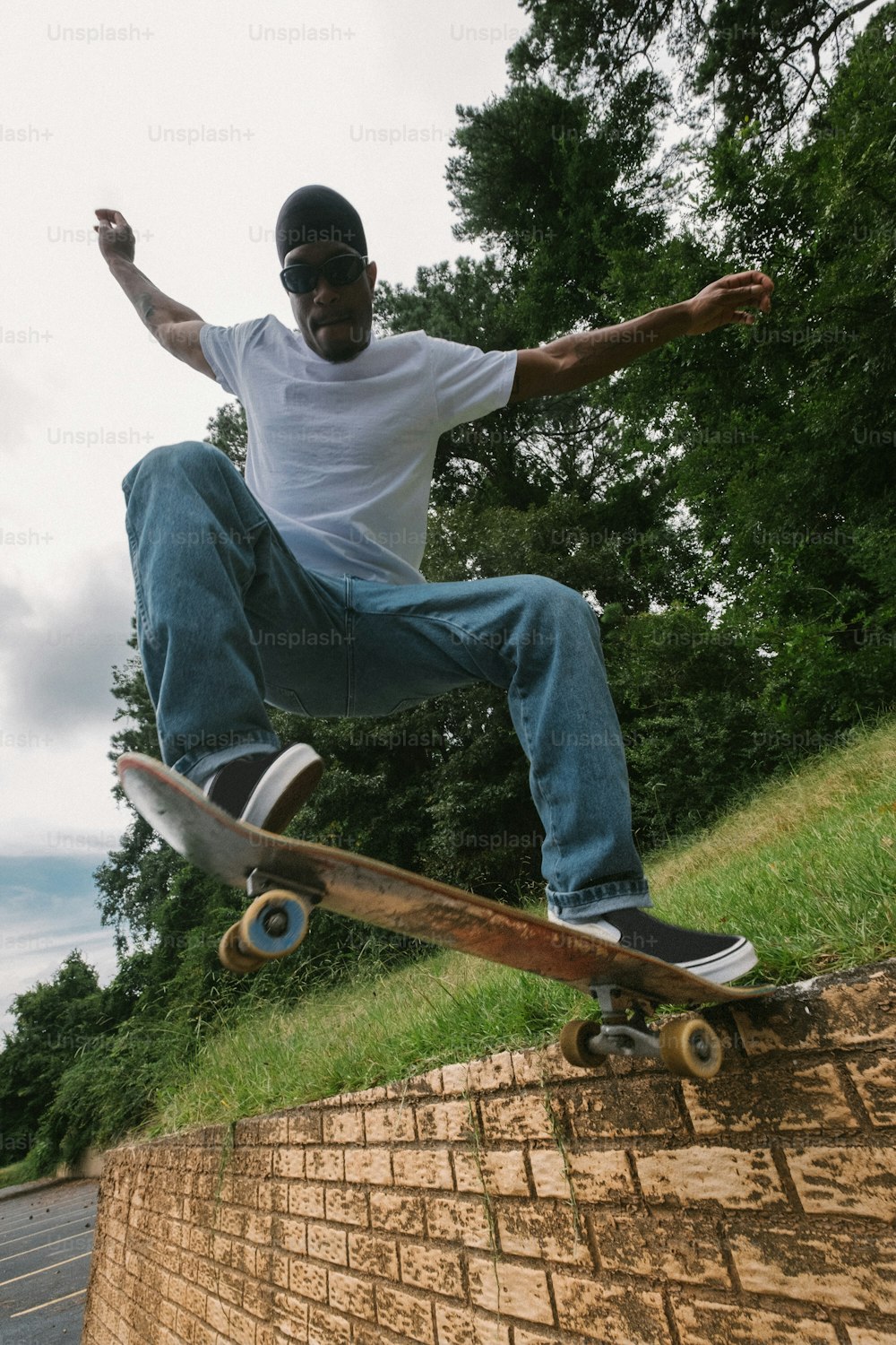 Un uomo che cavalca uno skateboard in cima a un muro di mattoni