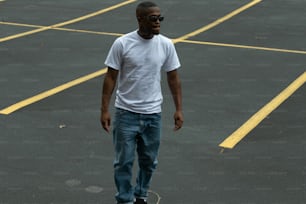 a man standing in a parking lot on a skateboard
