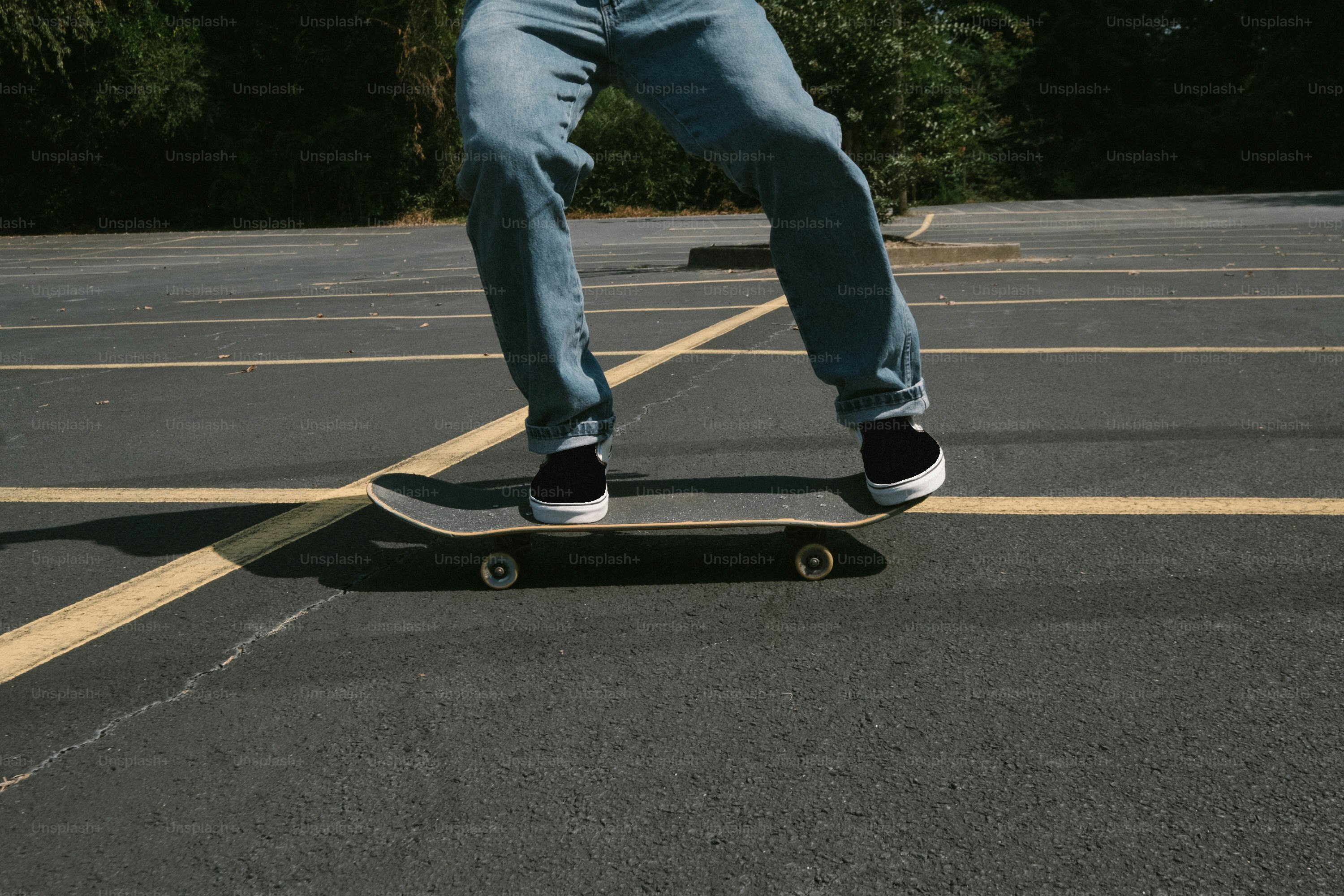Seorang pria mengendarai skateboard melintasi tempat parkir