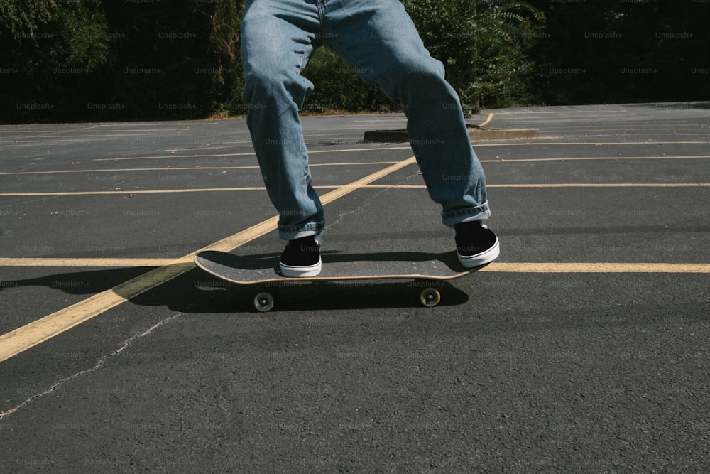 Ein Mann, der mit einem Skateboard über einen Parkplatz fährt