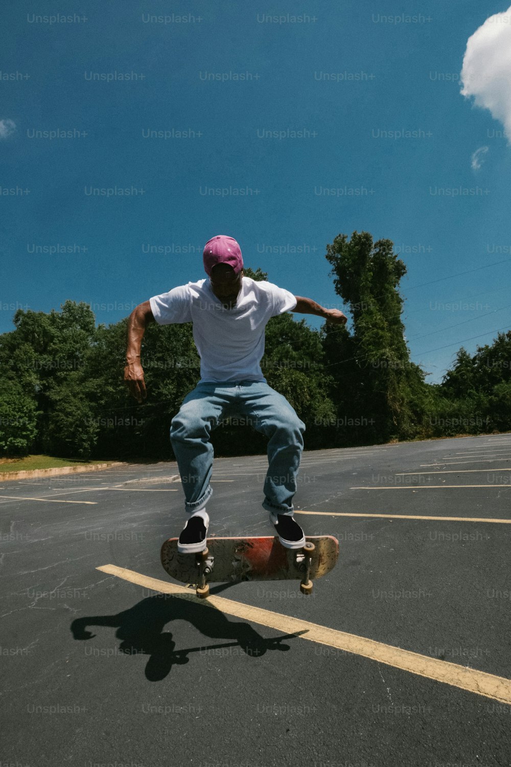 Un uomo che cavalca uno skateboard attraverso un parcheggio