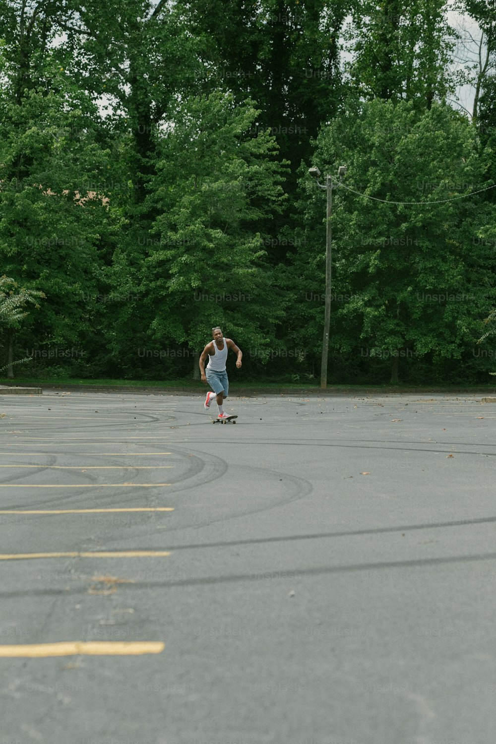 a man riding a skateboard across a parking lot