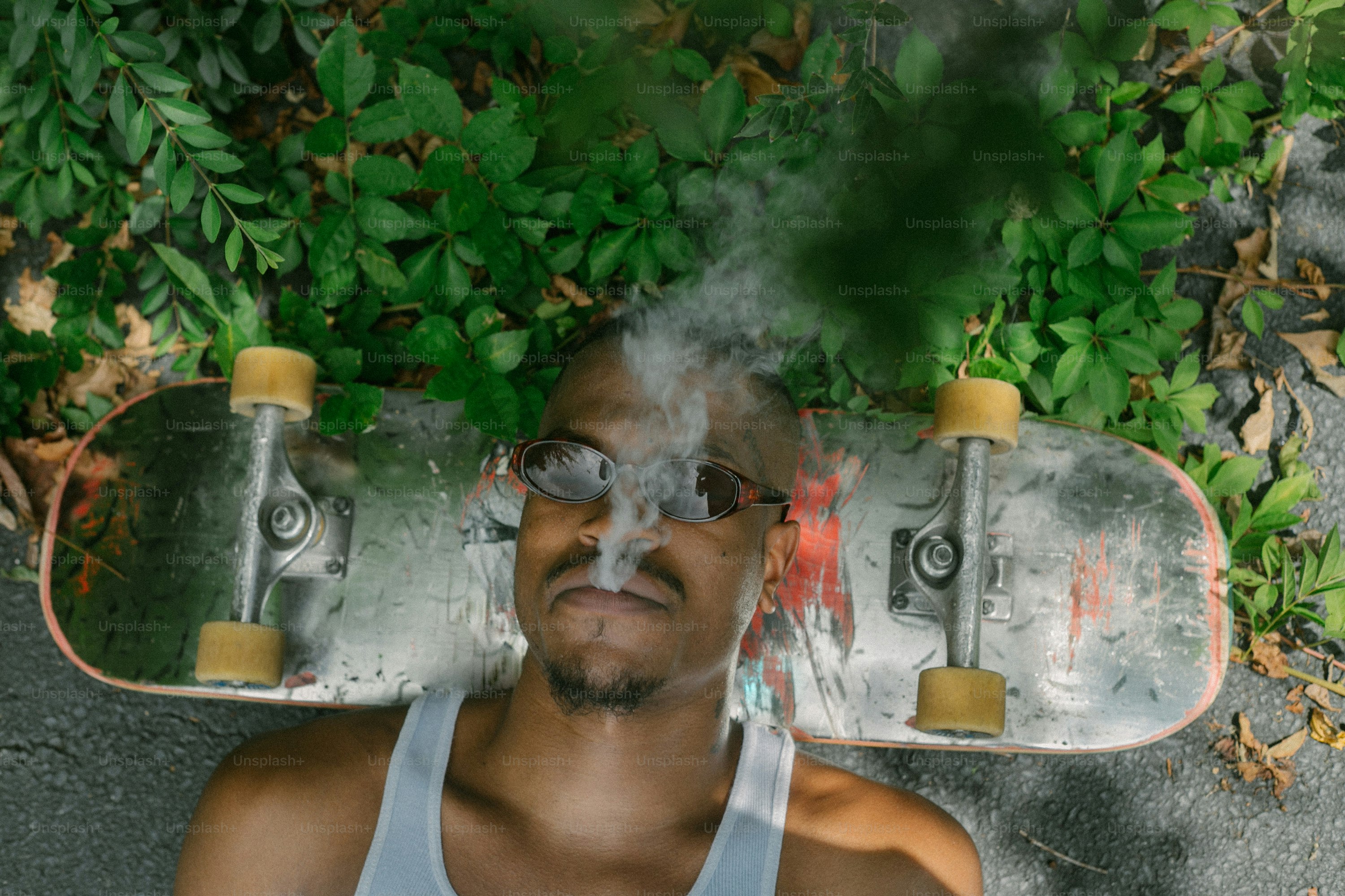 Un uomo con il fumo che esce dalla sua bocca accanto a uno skateboard