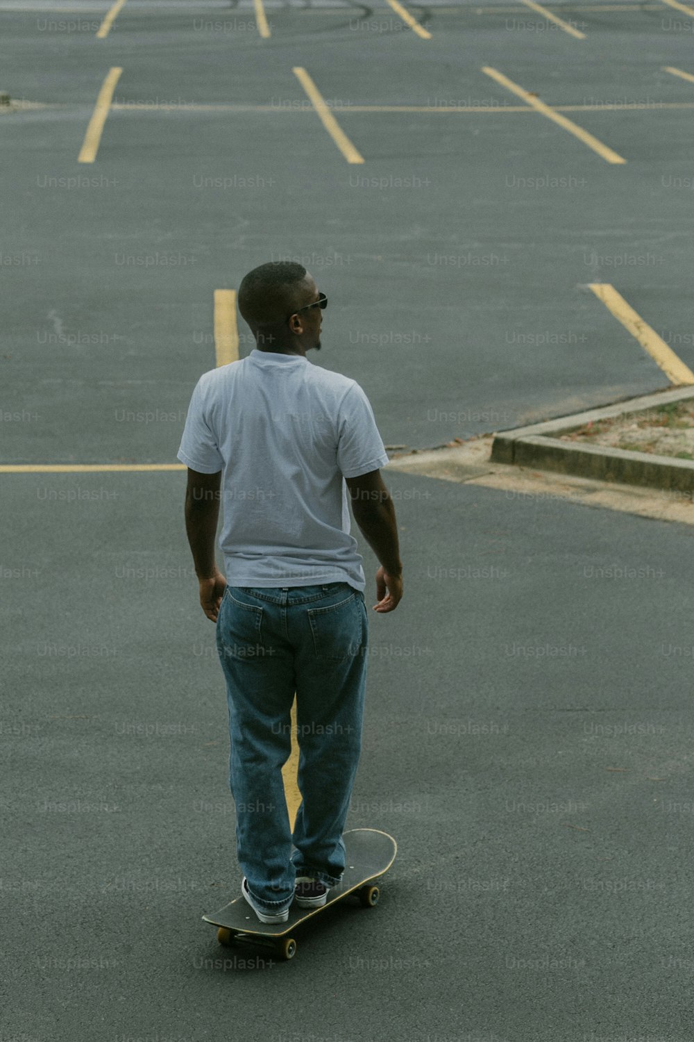 a man riding a skateboard across a parking lot