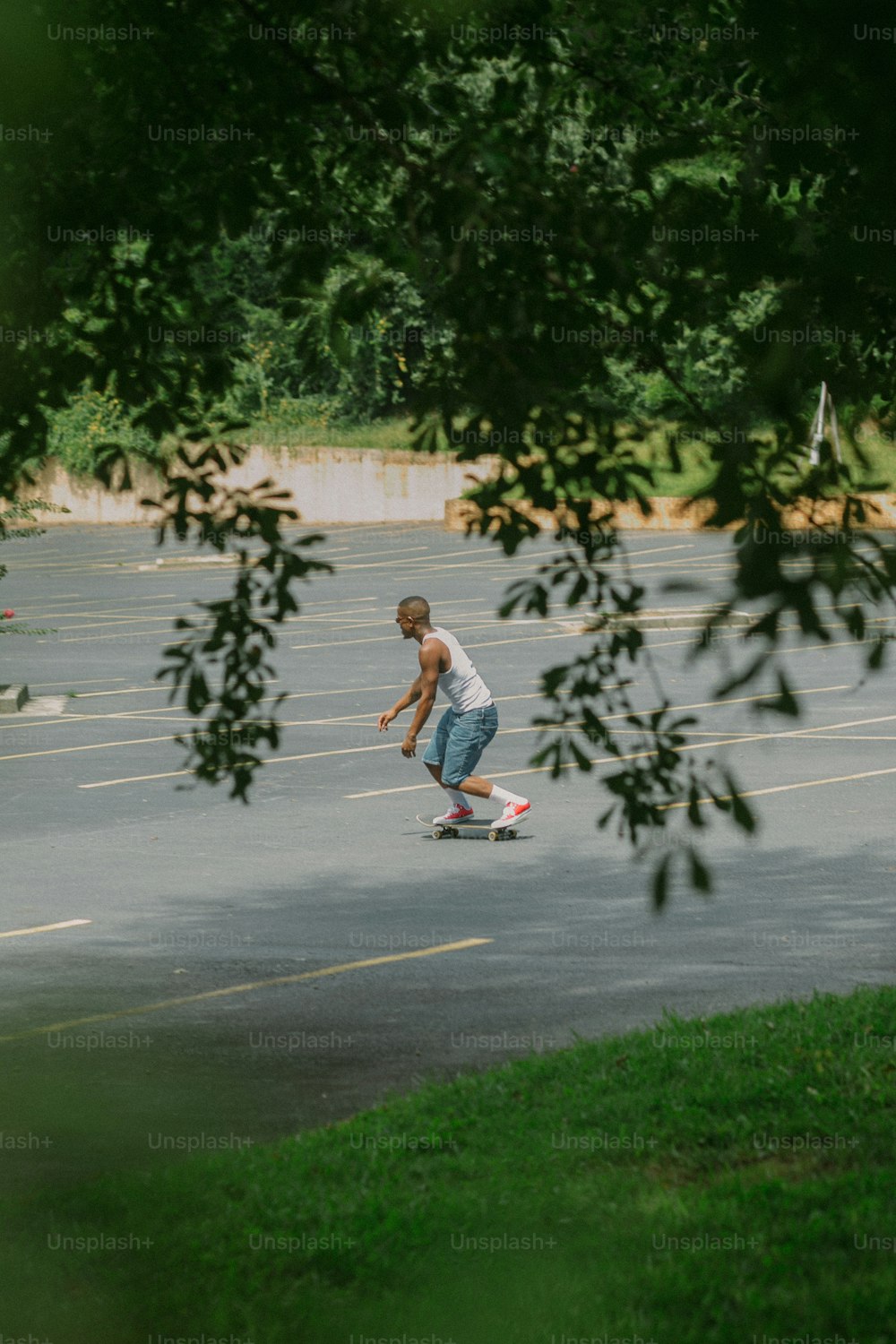 Un hombre montando una patineta en un estacionamiento