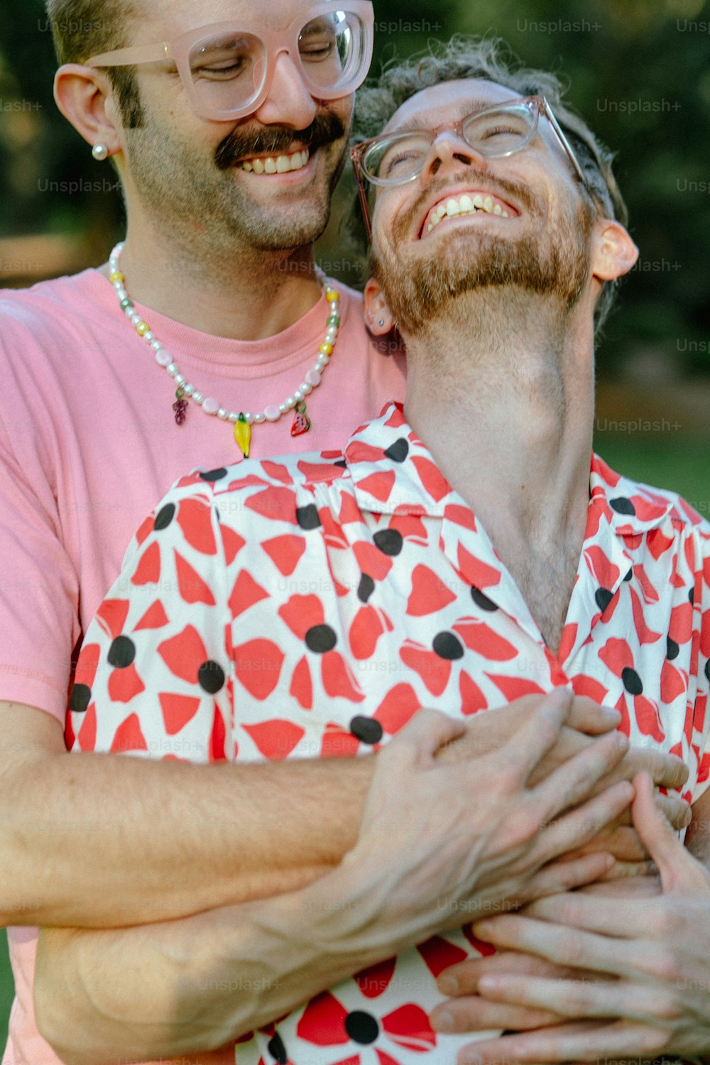 Un uomo in una camicia rosa che abbraccia un altro uomo in una camicia rosa