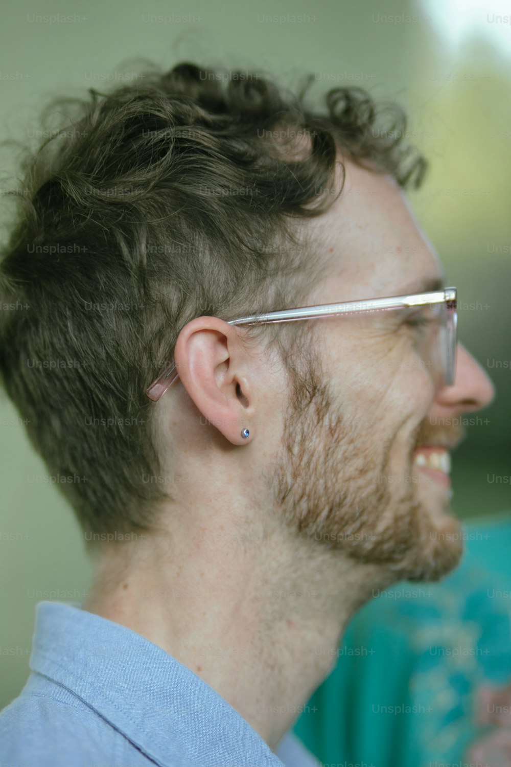 Un homme avec une barbe et des lunettes souriant