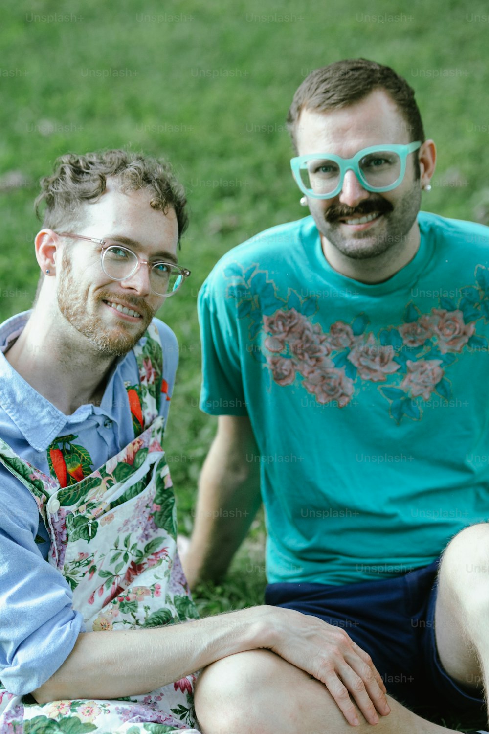 Un par de hombres sentados en la cima de un exuberante campo verde