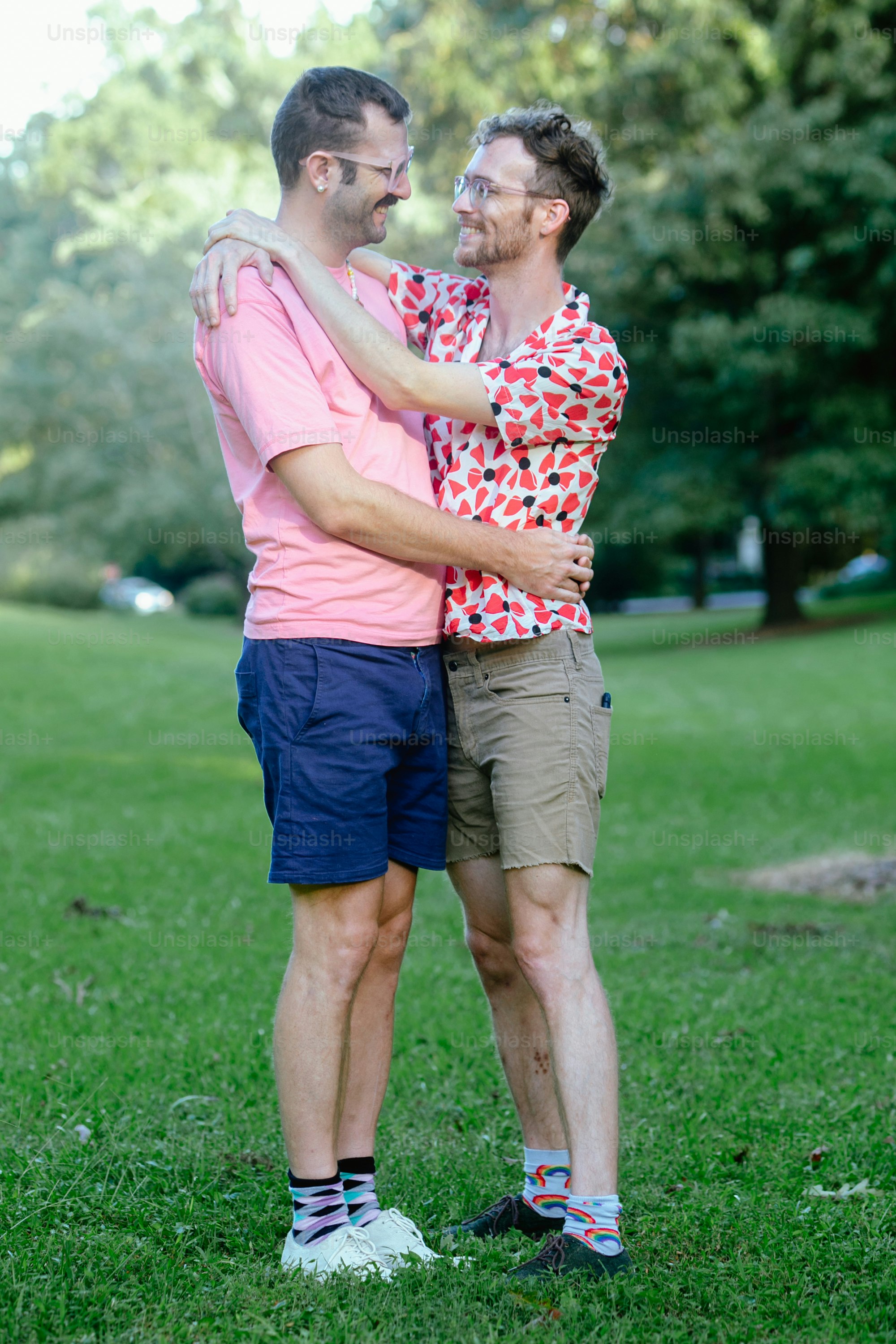 a couple of men standing next to each other on a lush green field
