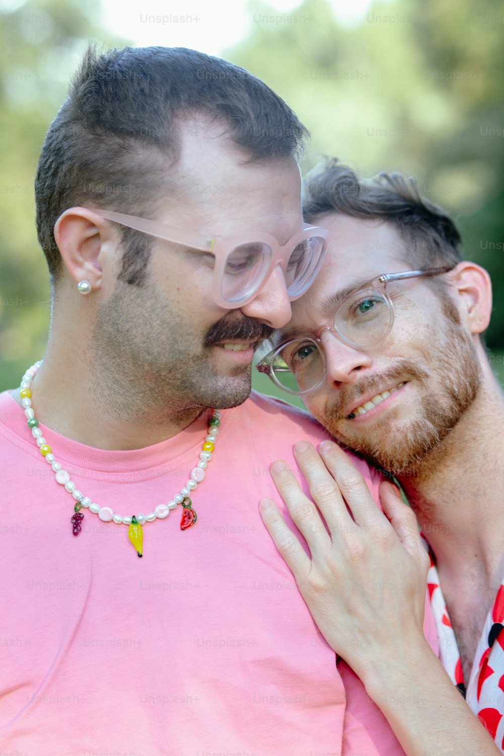 a man with a beard and glasses hugging another man