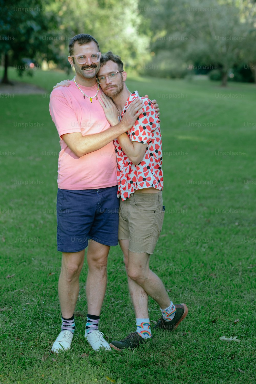 two men standing next to each other on a lush green field