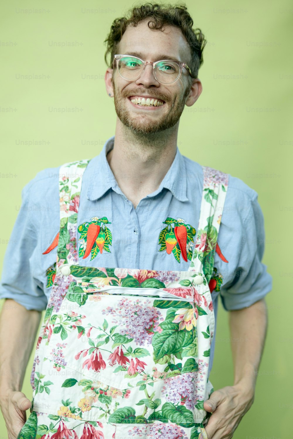 a man wearing glasses and a floral apron