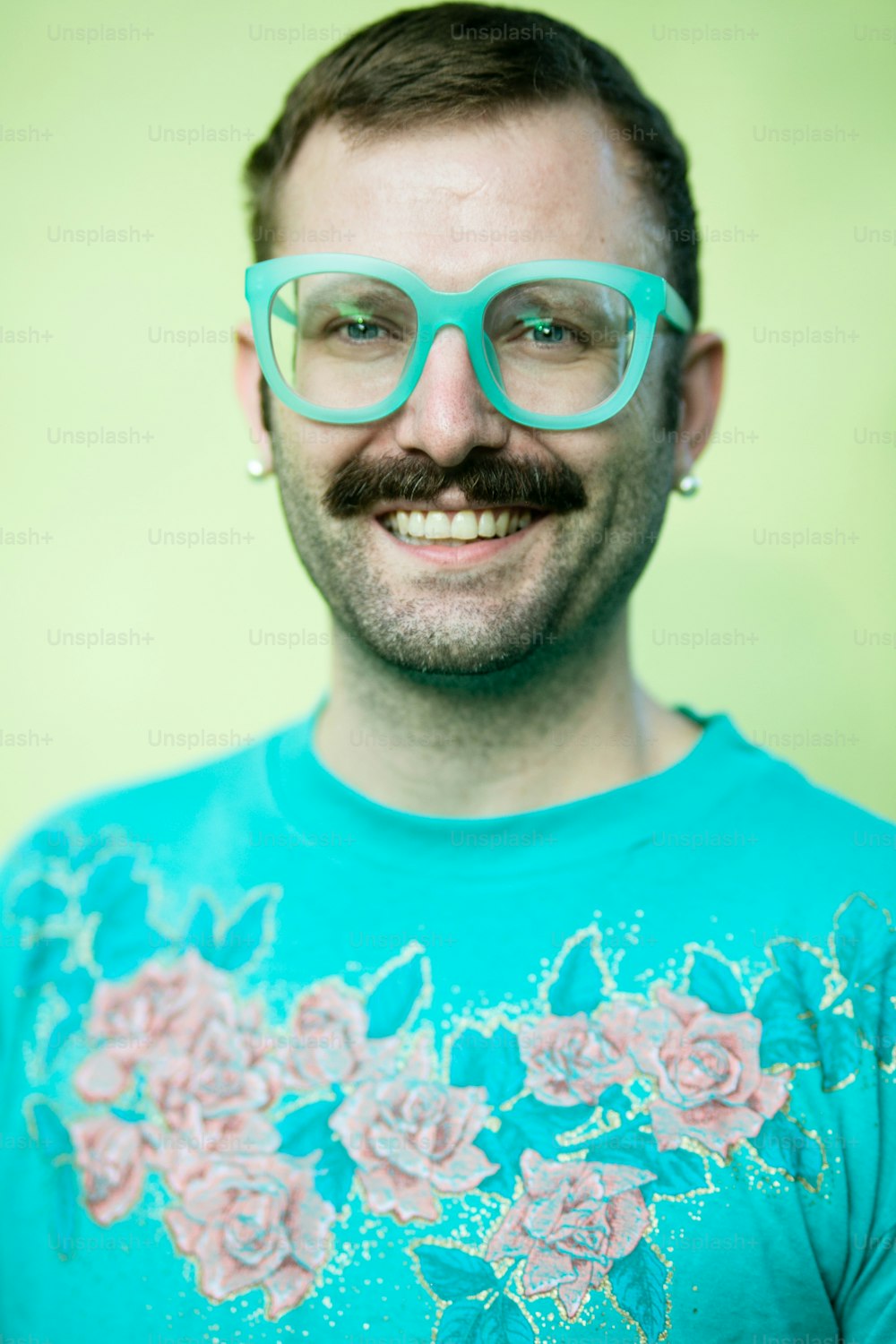 a man with a moustache wearing glasses