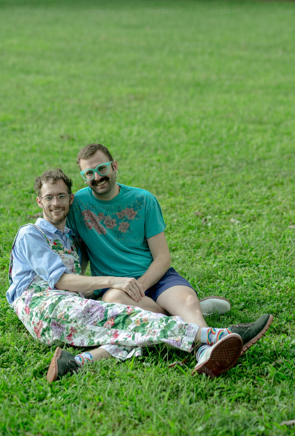 a man and a woman sitting on the grass