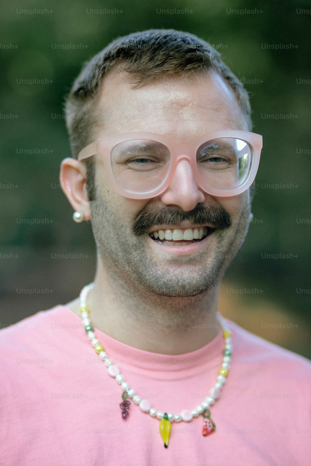 a man wearing glasses and a pink shirt