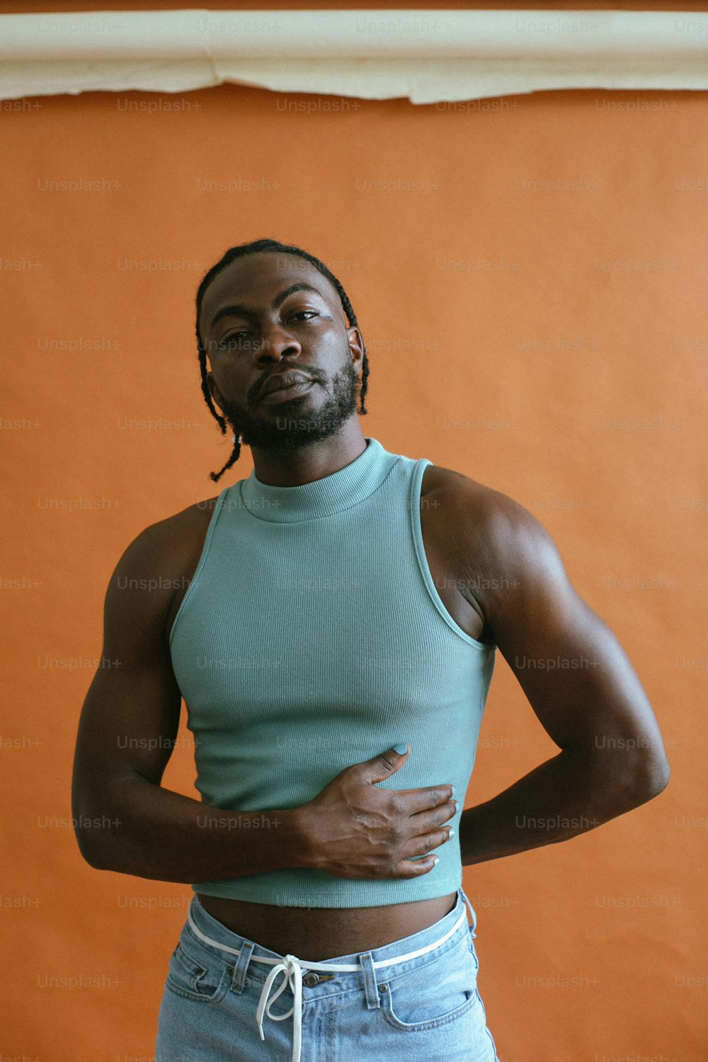 a man in a tank top standing with his hands on his hips